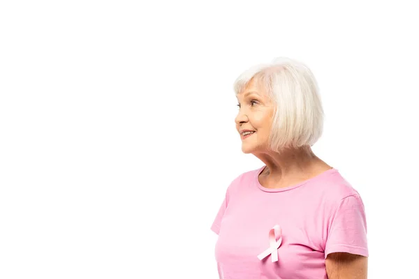 Donna dai capelli grigi con nastro di consapevolezza del cancro al seno su t-shirt distogliendo lo sguardo isolato sul bianco — Foto stock