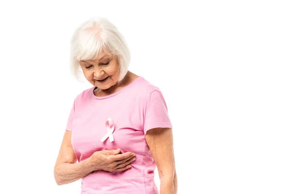 Seniorin betrachtet rosafarbenes Band des Brustkrebsbewusstseins isoliert auf weißem Grund — Stockfoto