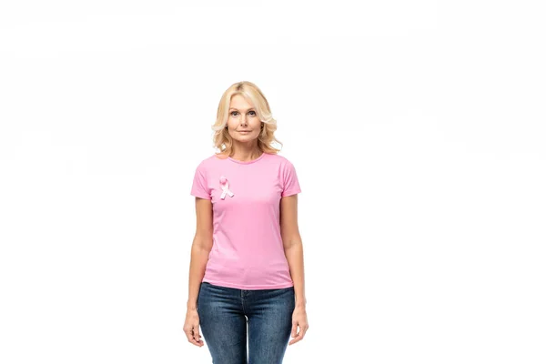 Blonde woman with pink ribbon of breast cancer awareness looking at camera isolated on white — Stock Photo