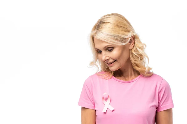 Donna bionda guardando nastro rosa di consapevolezza del cancro al seno isolato su bianco — Foto stock