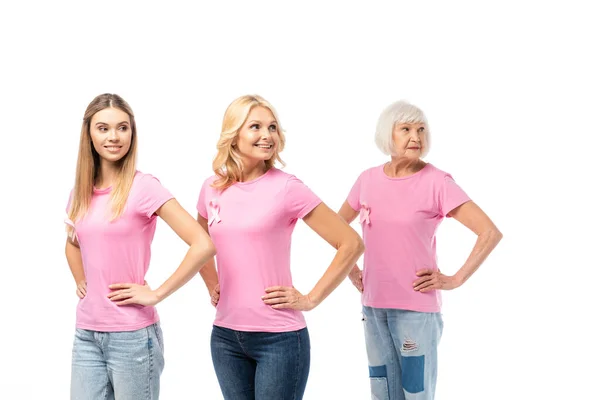 Donne con le mani sui fianchi e nastri di consapevolezza del cancro al seno isolato su bianco — Foto stock