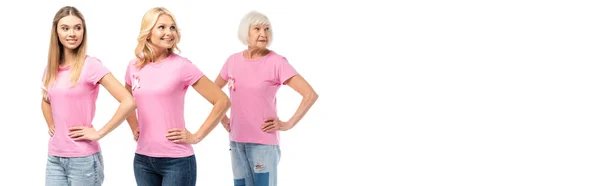 Panoramic crop of women with pink ribbons of breast cancer awareness and hands on hips looking away isolated on white — Stock Photo