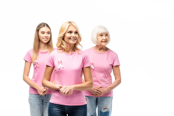 Donne in t-shirt rosa e nastri di consapevolezza cancro al seno guardando lontano isolato su bianco — Foto stock