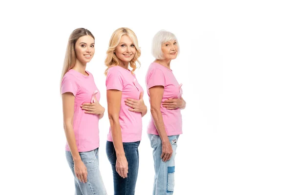 Mujeres con cintas rosas en camisetas mirando a la cámara aislada en blanco - foto de stock