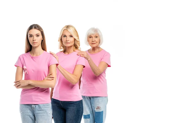 Mujeres con cintas rosadas de conciencia sobre el cáncer de mama abrazándose aisladas en blanco - foto de stock