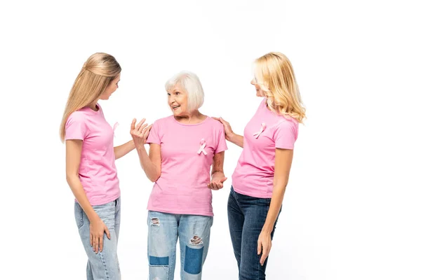 Senior woman talking to women with ribbons of breast cancer awareness isolated on white — Stock Photo