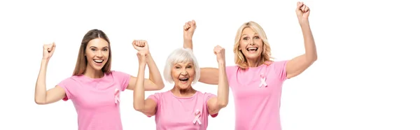 Imagen horizontal de mujeres excitadas en camisetas con cintas de conciencia de cáncer de mama mostrando sí gesto aislado en blanco - foto de stock