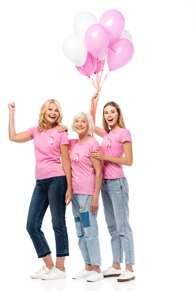 Women with ribbons of breast cancer awareness showing yeah and holding balloons on white background — Stock Photo