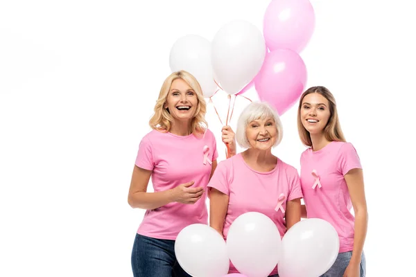 Жінки зі стрічками поінформованості про рак молочної залози тримають повітряні кулі ізольовані на білому — стокове фото