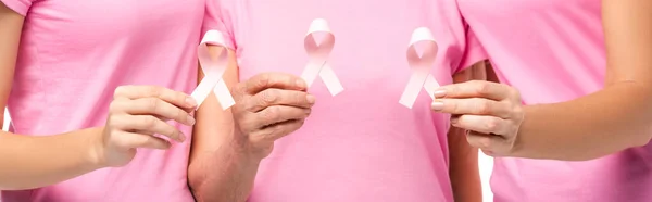 Foto panorámica de mujeres sosteniendo cintas rosadas de conciencia de cáncer de mama aisladas en blanco - foto de stock