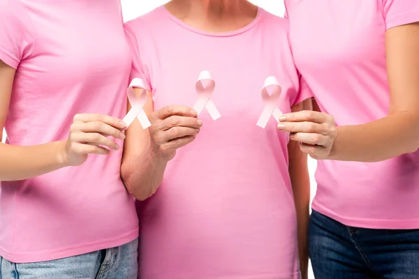 Vista recortada de las mujeres en camisetas rosas que muestran cintas de conciencia de cáncer de mama aisladas en blanco - foto de stock