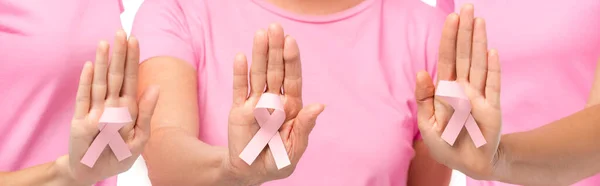 Image horizontale de femmes montrant un ruban de sensibilisation au cancer du sein sur des paumes isolées sur du blanc — Photo de stock