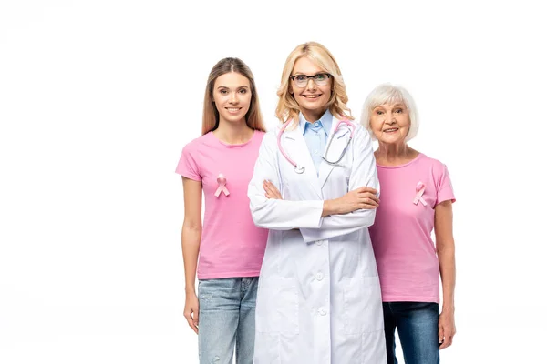 Médecin regardant la caméra près des femmes avec des rubans roses sur des t-shirts isolés sur blanc — Photo de stock