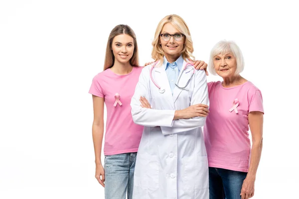 Women with ribbons of breast cancer awareness hugging doctor isolated on white — Stock Photo