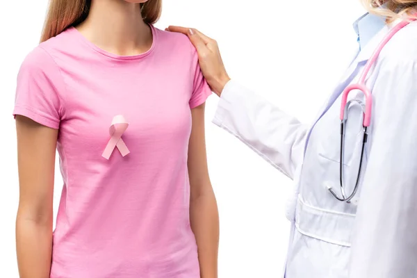 Vista cortada do médico com estetoscópio abraçando a jovem com fita de consciência do câncer de mama isolado no branco — Fotografia de Stock