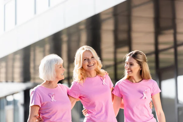 Selektiver Fokus von drei Frauen mit Brustkrebsbändern im Freien — Stockfoto