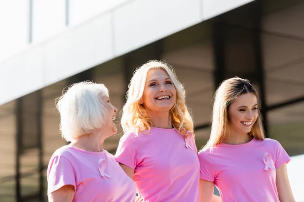 Selective focus of women with signs of breast cancer awareness laughing outdoors — Stock Photo