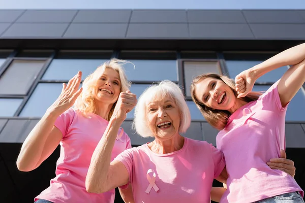 Vue à angle bas des femmes avec geste ouais regardant la caméra à l'extérieur — Photo de stock