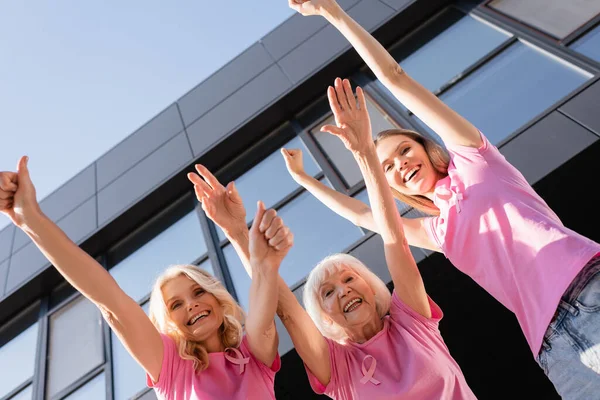 Vue à faible angle des femmes avec les mains dans l'air et l'approbation, concept de cancer du sein — Photo de stock