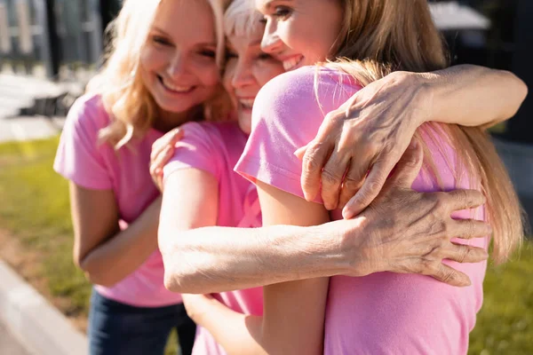 Focus selettivo delle donne in t-shirt rosa che abbracciano, concetto di cancro al seno — Foto stock