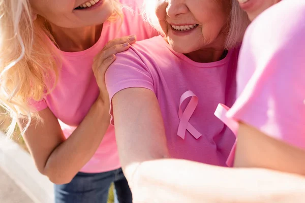 Close up view of women with signs of breast cancer awareness embracing outdoors — Stock Photo