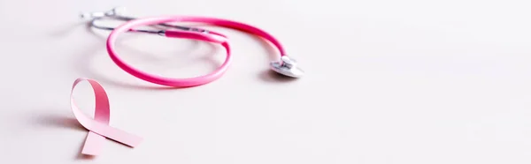 Panoramic shot of stethoscope and pink ribbon isolated on white — Stock Photo