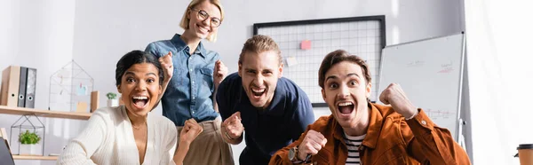 Схвильовані багатоетнічні бізнес-колеги кричать і показують жест виграшу, банер — стокове фото