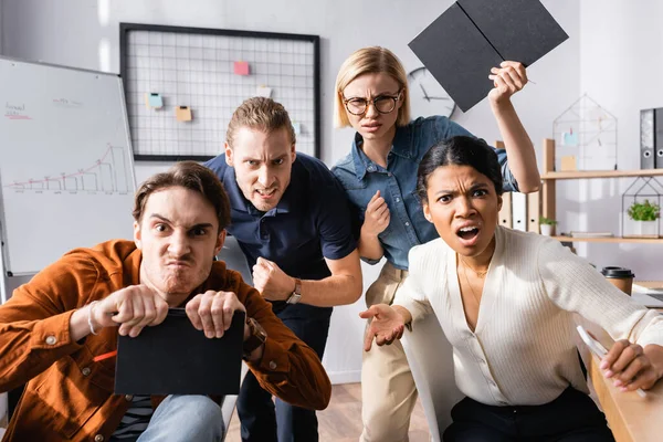 Aggressive multicultural businesspeople shouting while looking at camera — Stock Photo