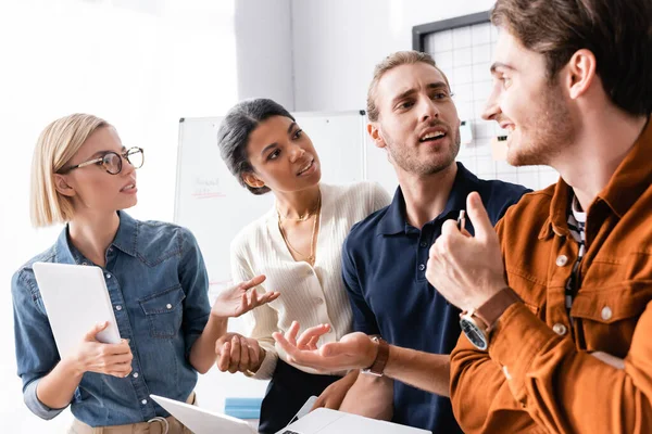 Jóvenes empresarios multiculturales discutiendo proyecto juntos - foto de stock