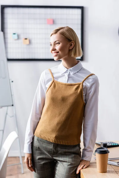 Cheerful young businesswoman looking away in office near workplace — Stock Photo