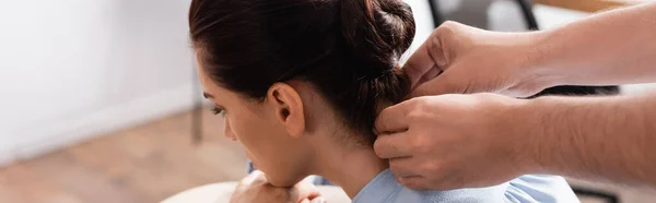 Masajista haciendo masaje de cuello de mujer de negocios morena sobre fondo borroso, pancarta - foto de stock