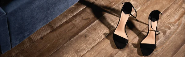 Zapatos negros de tacón alto en piso de madera, pancarta - foto de stock