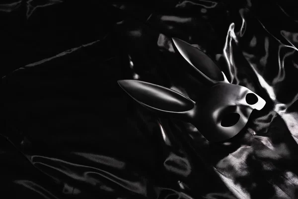 Máscara de coelho sexual em cama de cetim preto — Fotografia de Stock