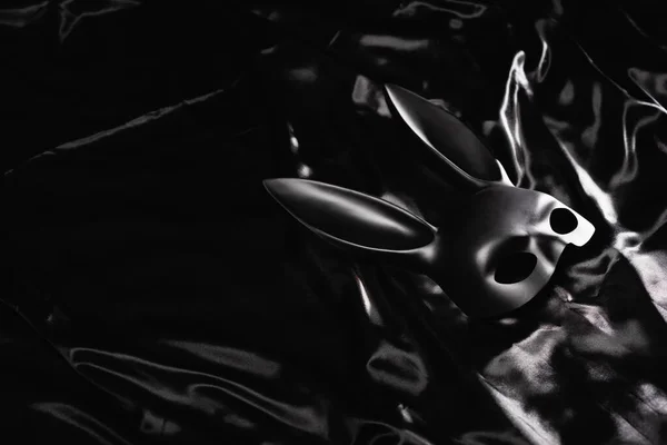 Maschera coniglietto sessuale su biancheria da letto di raso nero — Foto stock