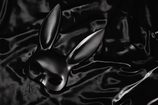 Top view of bdsm rabbit mask on silk bedding — Stock Photo