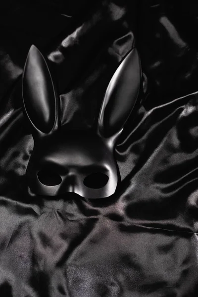 Top view of black bdsm rabbit mask on satin bedding — Stock Photo