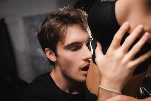 Leidenschaftlicher Mann küsst Bauch einer sinnlichen Frau auf verschwommenem Vordergrund zu Hause — Stockfoto