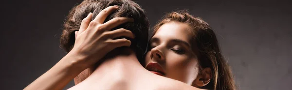 Donna seducente con labbra rosse che abbracciano il fidanzato senza maglietta a casa, banner — Foto stock