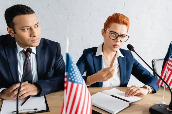 Grave politico donna che fa gesti, mentre parla al microfono vicino alla collega indiana durante il congresso del partito politico — Foto stock