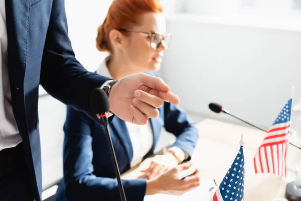 Politician pointing with finger, while standing near female colleague on blurred background — Stock Photo