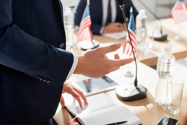 Vista recortada del gesto político, mientras estaba de pie durante la convención con el hombre borroso en el fondo — Stock Photo