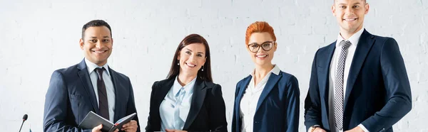 Glückliche multikulturelle Politiker blicken in die Kamera im Sitzungssaal, Transparent — Stockfoto