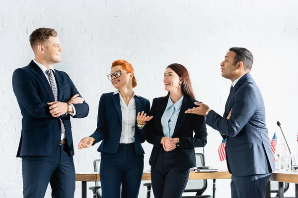 Happy interracial politicians gesturing while talking in boardroom — Stock Photo