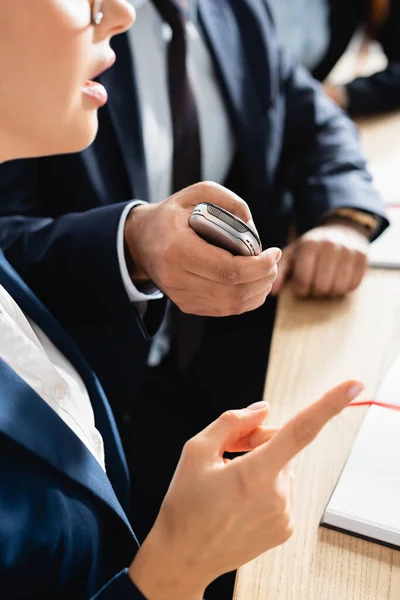 Vista ritagliata del corrispondente con dittatore intervistando politico che punta con il dito durante la conferenza stampa su sfondo sfocato — Foto stock