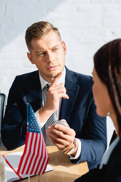 Journalist with dictaphone interviewing politician during party congress on blurred foreground — Stock Photo