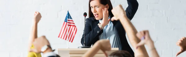 Candidato sorprendido delante de los votantes mostrando pulgares hacia abajo en la sala de conferencias, pancarta — Stock Photo