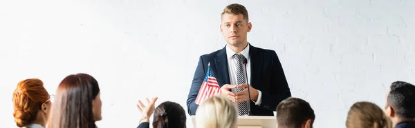 Agitador político serio hablando con los votantes en la sala de conferencias, pancarta — Stock Photo