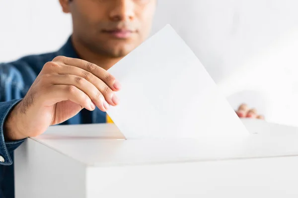 Vista recortada del hombre indio insertando boleta electoral en la cabina de votación - foto de stock