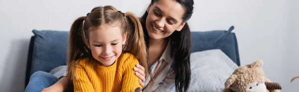 Fröhliche Mutter berührt lächelnde Tochter zu Hause, Transparent — Stockfoto