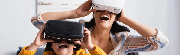 Mujer emocionada con hija usando auriculares vr, bandera - foto de stock